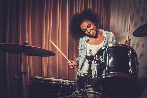 笑顔でドラムを演奏する女性